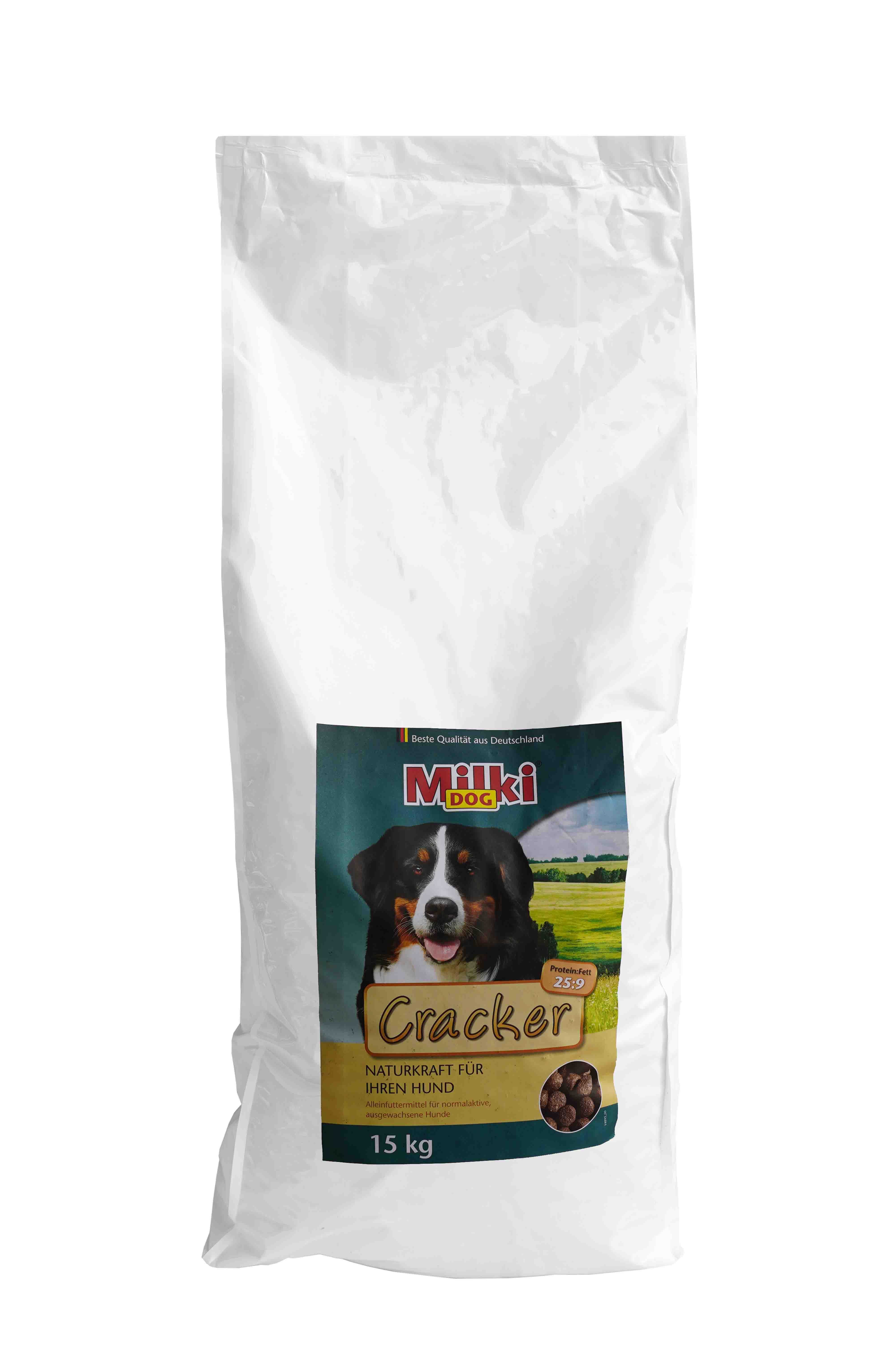 Eine große weiße Futtersack-Tüte mit der Aufschrift „Milki Dog Cracker“. Auf dem Etikett ist ein Bild eines glücklichen Bernhardiners vor einer grünen Wiese und blauem Himmel abgebildet. Auf der Tüte steht außerdem „Naturkraft für Ihren Hund“ und „Alleinf